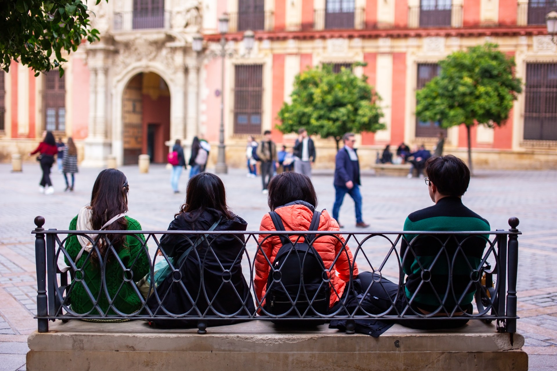 Estudiantes descansando en un banco de una plaza de Sevilla