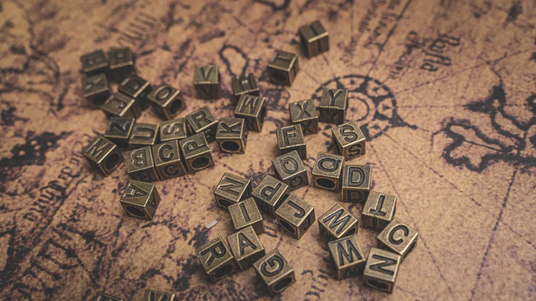 Letras de bronce sobre un antiguo mapa del mundo