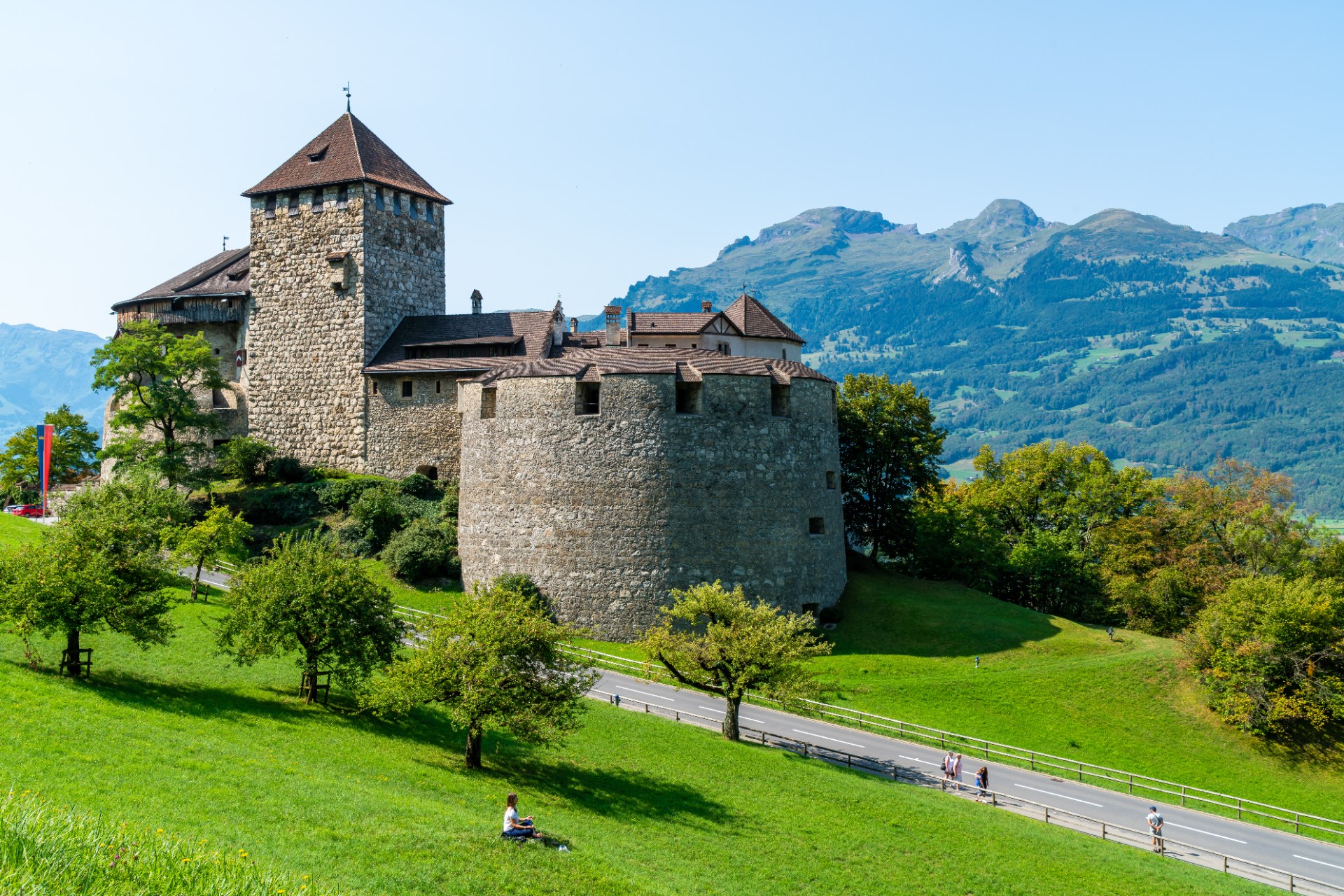 El castillo de Vaduz en una ladera verde con las montañas al fondo, en Liechtenstein