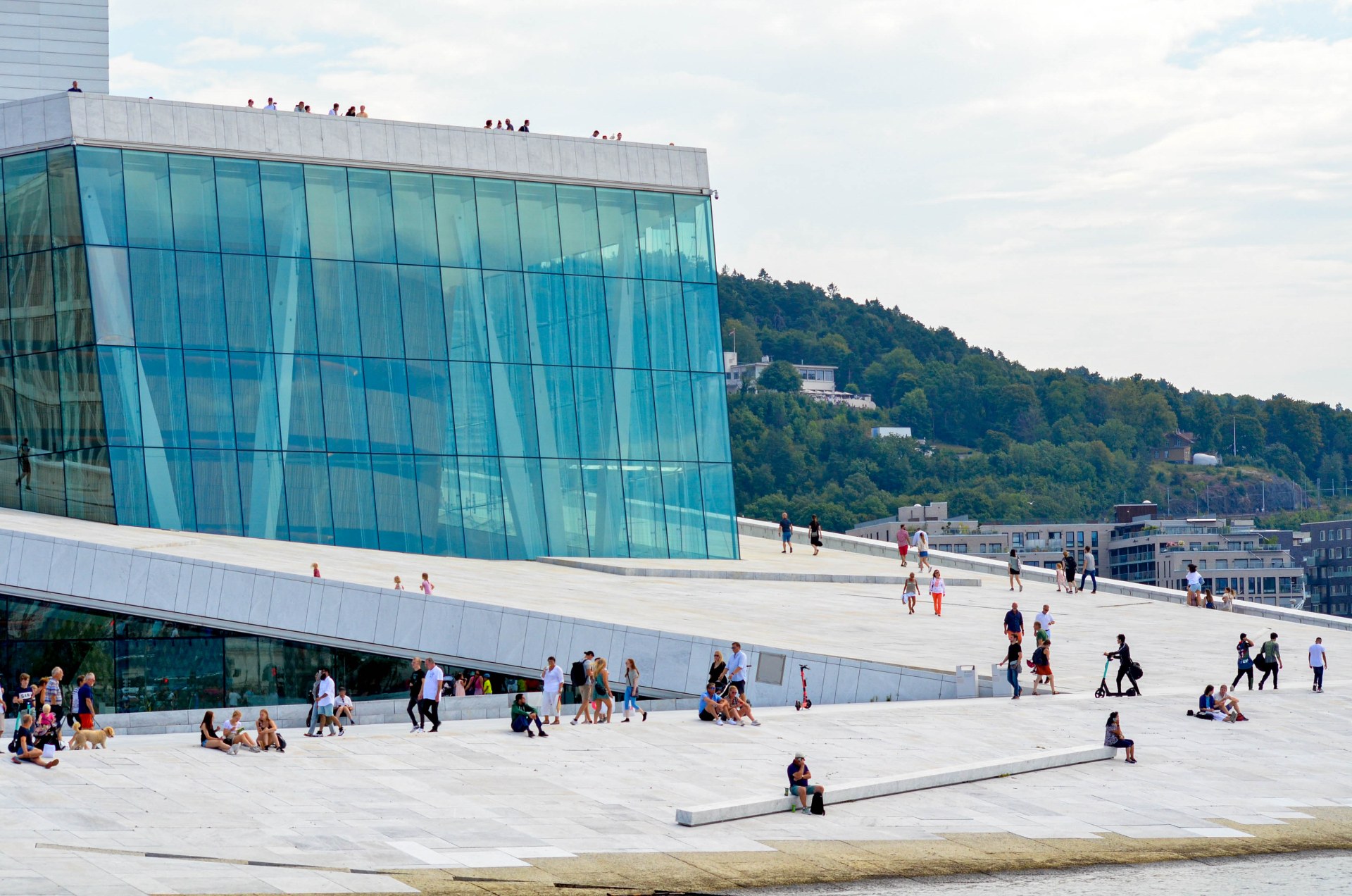 Gente paseando y descansando en el tejado de la Ópera de Oslo
